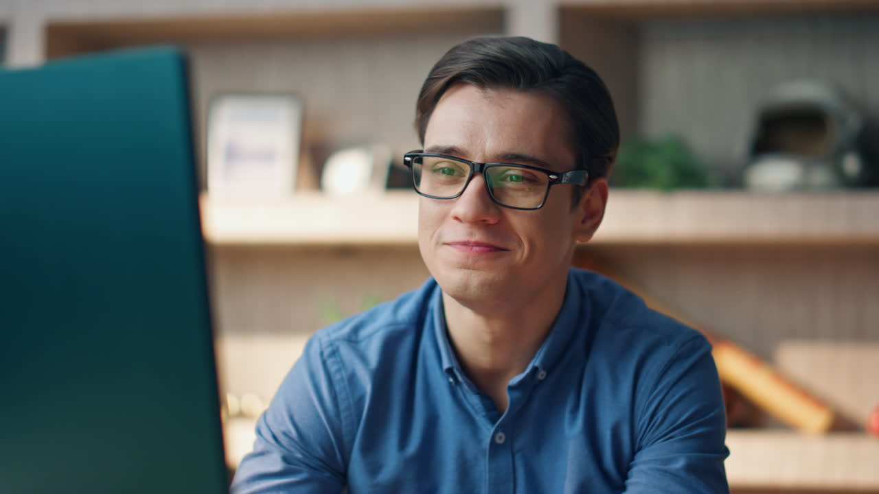 un trabajador independiente sonriente terminando el video chat de la oficina de primer plano. hombre mostrando el gesto de paz