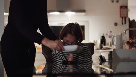 teen boy watching video while eating spaghetti