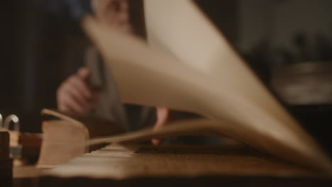 old passionate man writes a letter in his office at night