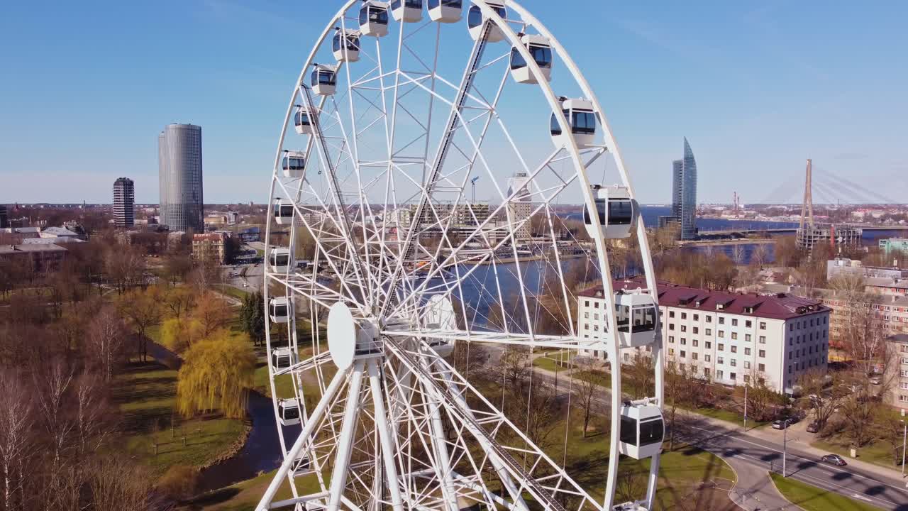 Ferris wheel with cityscape and river view, bright sunny day in Riga, Latvia