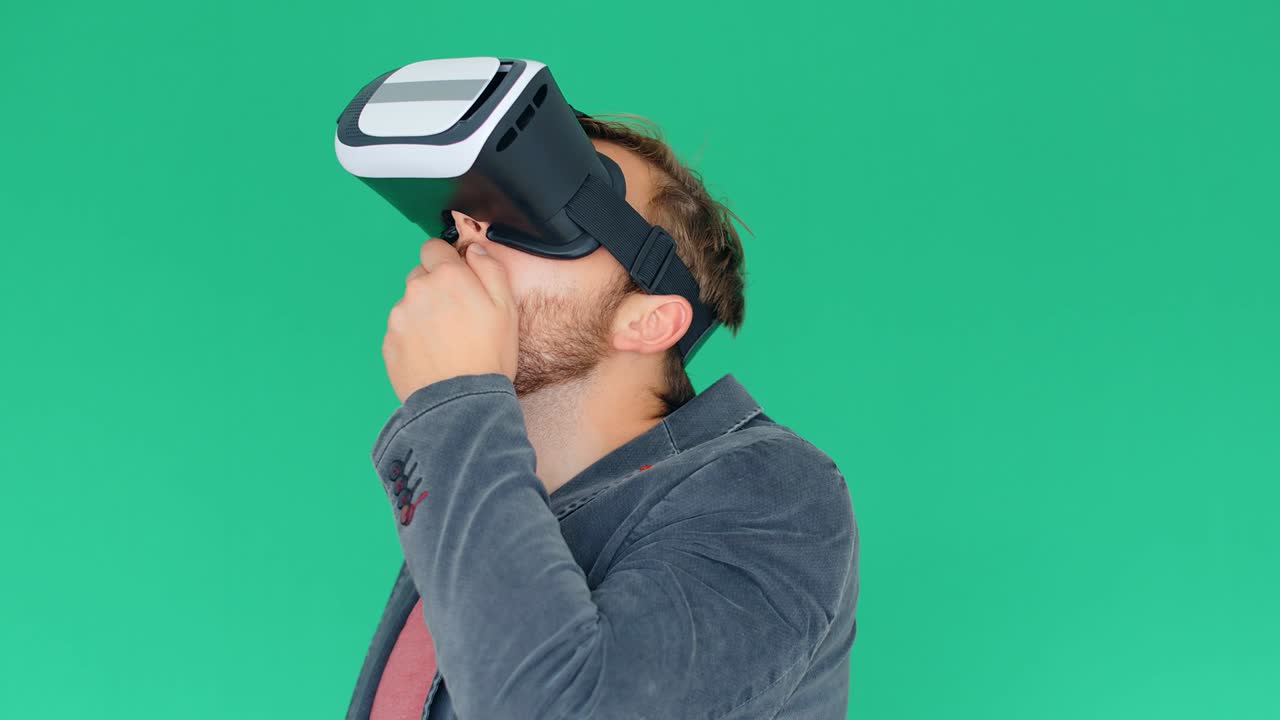 Young man using modern virtual reality glasses on green screen background, 4k