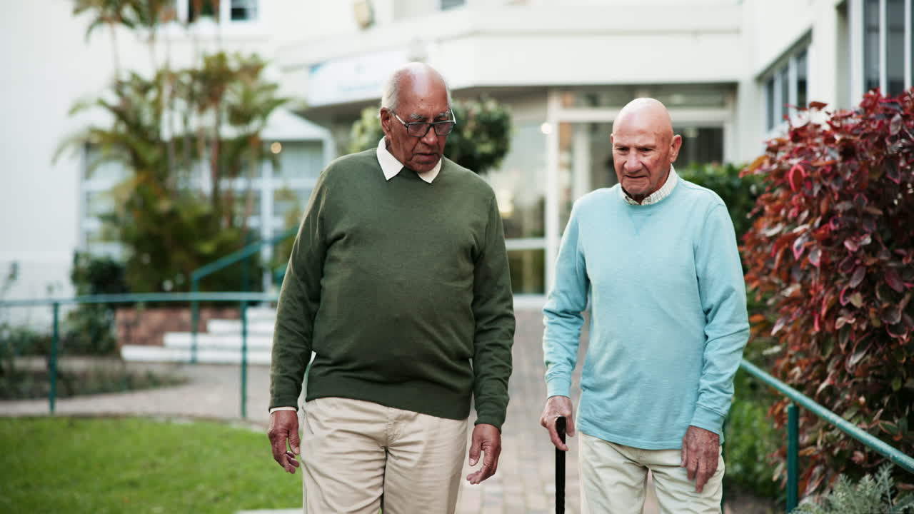 Two elderly men walking and talking outdoors