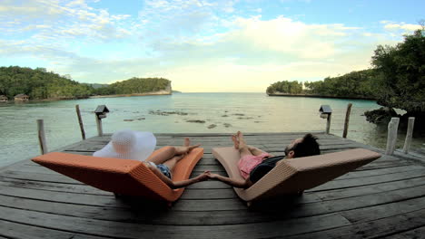 couple relaxing on a tropical pier