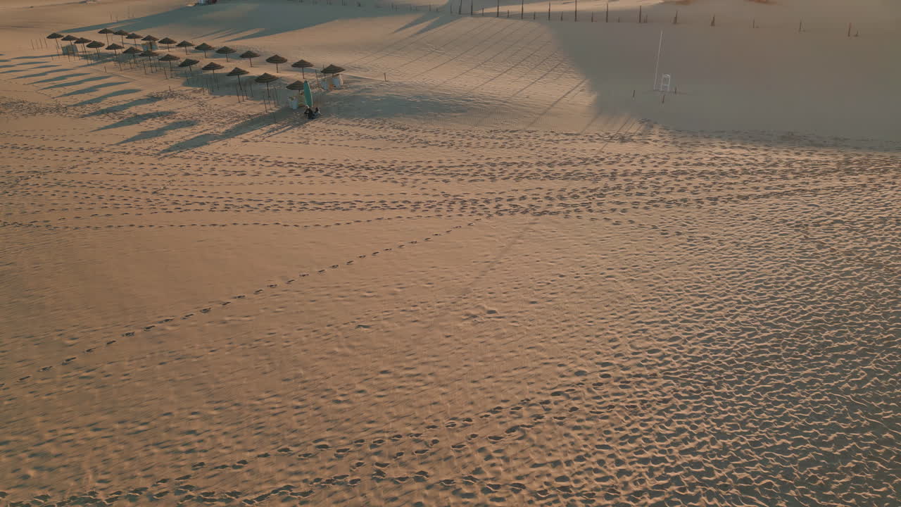 Loose sand sunny desert aerial view. Drone panorama green hills silhouettes
