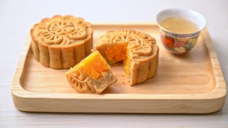 Chinese-moon-cake-durian-and-egg-yolk-flavour-with-tea-on-wood-plate