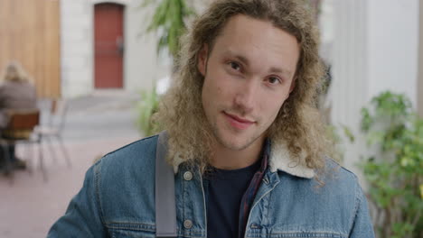 portrait of attractive young man smiling confident looking at camera enjoying independent student lifestyle in urban outdoors campus background