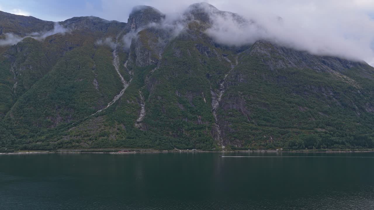 Moottorivene lipuu tyynessä Norjan vuonossa.