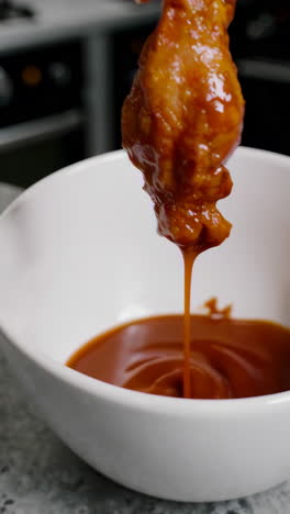 dipping chicken wings in sauce