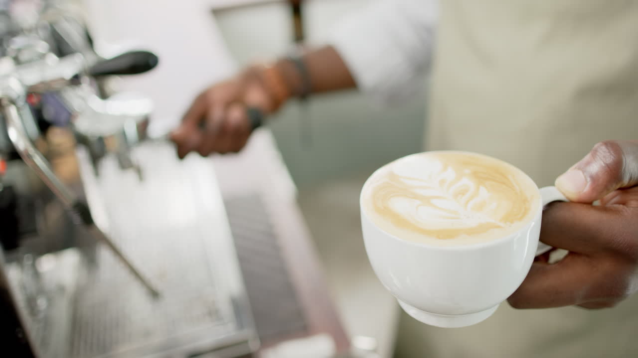 African American barista presents a freshly made cappuccino with latte art