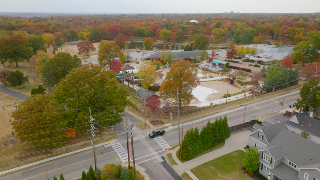 미주리 주 커크우드의 멋진 동네와 레크리에이션 센터와 공원을 넘어 아름다운 가을 나무를 향해 날아갑니다.