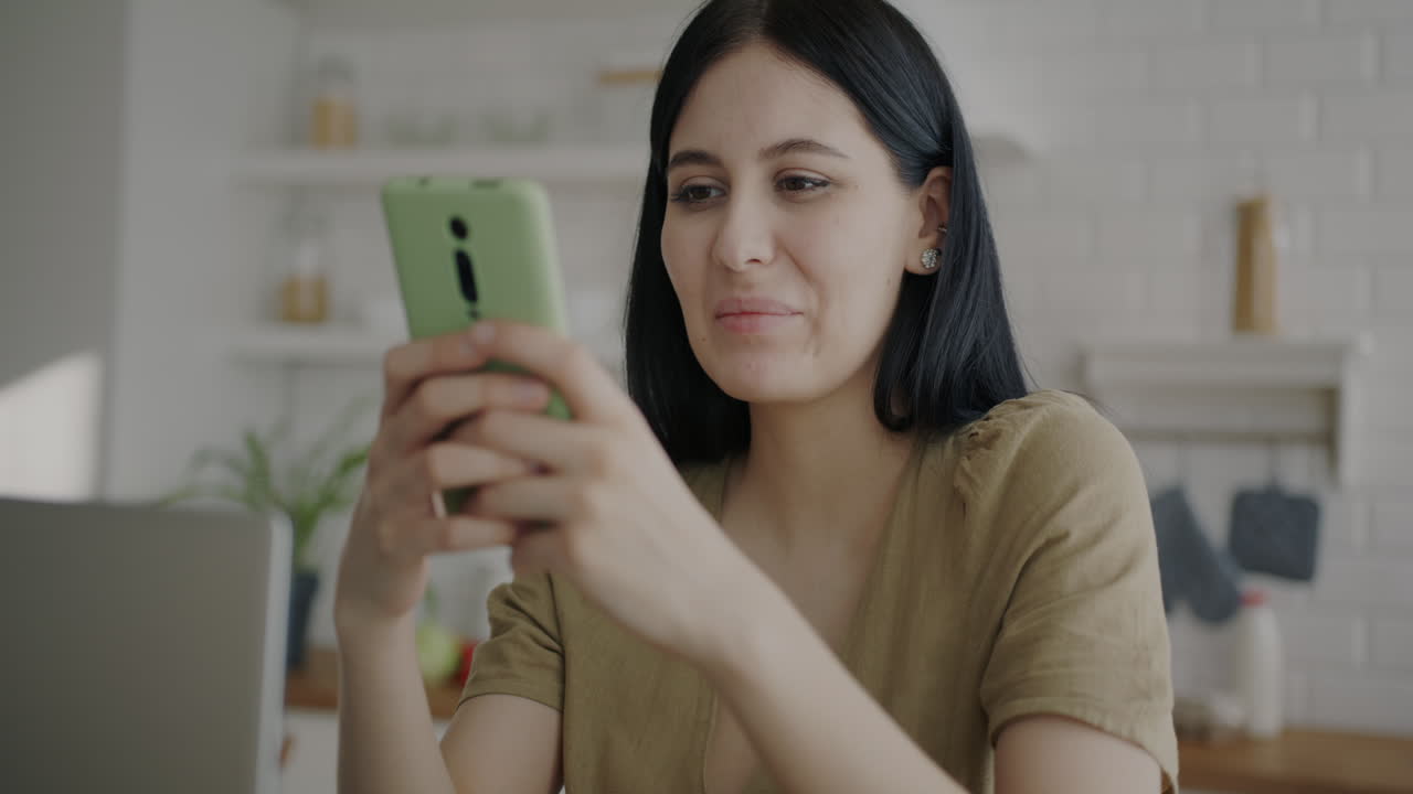 mujer usando un teléfono en una cocina