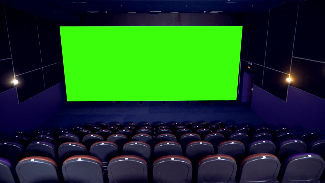 Empty cinema hall with blank movie theater screen with green screen background.