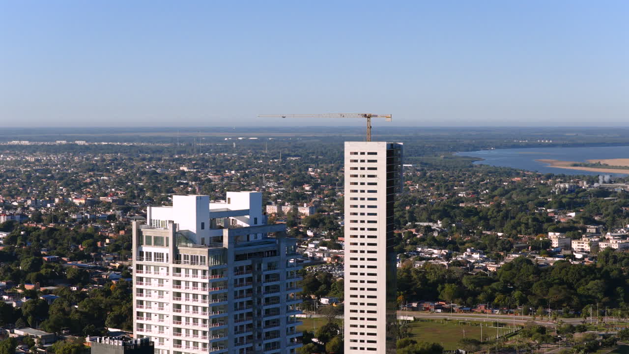 Drone footage of modern high-rise buildings dominating the urban skyline of Corrientes City surrounded by residential areas