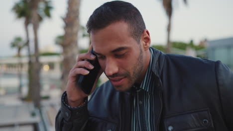 young man calling on smartphone outdoors.