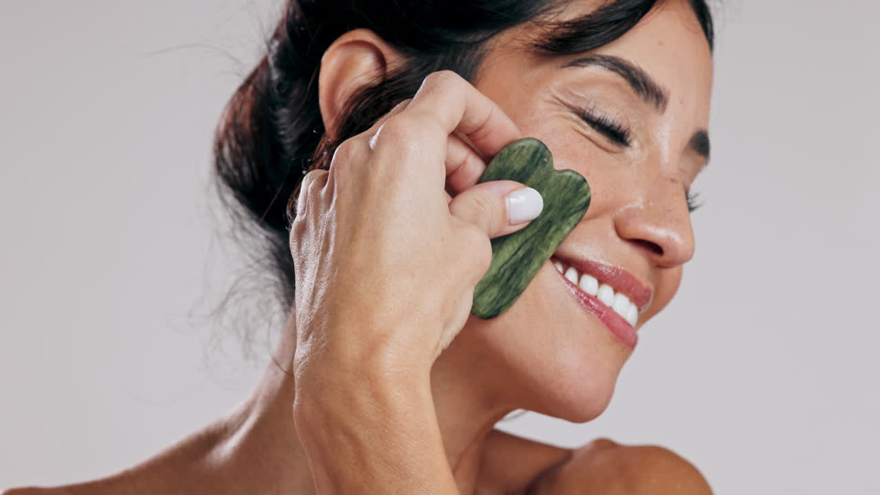 mujer disfrutando de un masaje facial de gua sha