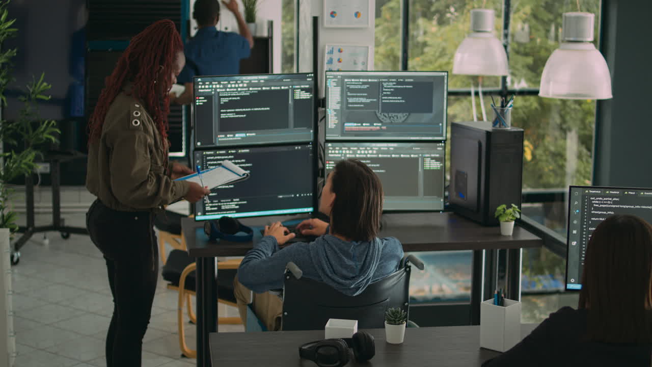 Female developer analyzing program code and talking to asian engineer