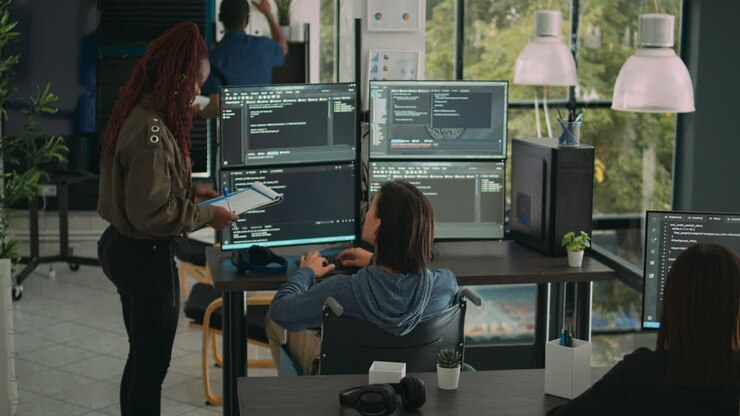 Female developer analyzing program code and talking to asian engineer