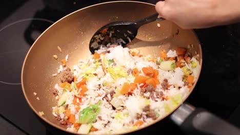 stirring and frying rice with vegetables