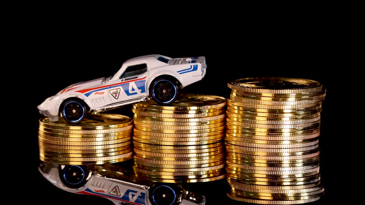 White toy car rotates atop gold coin stacks, black reflective background, dramatic studio lighting