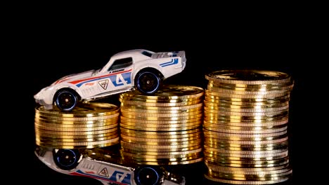 white toy car rotates atop gold coin stacks, black reflective background, dramatic studio lighting