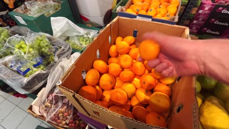 un estante con frutas y verduras en una tienda de comestibles, las mandarinas están en contenedores