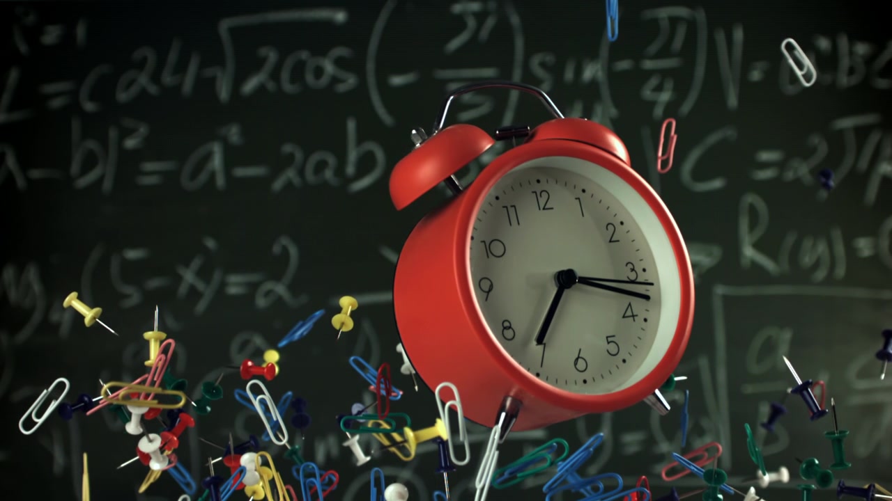 Red Alarm Clock and School Supplies Falling in Front of Math Chalkboard