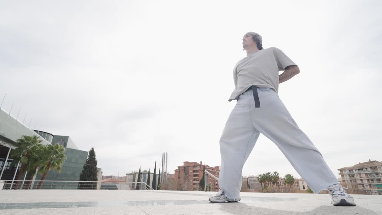 Breakdancer performing various moves in urban setting