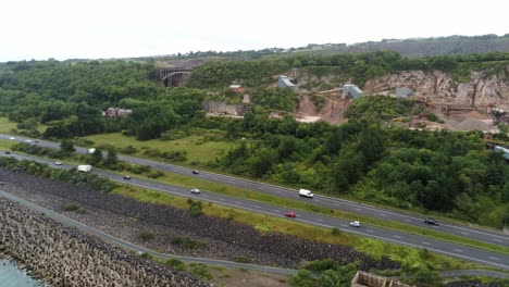 Cemex-mining-site-on-North-Wales-expressway-traffic-aerial-rising-view-over-construction-site