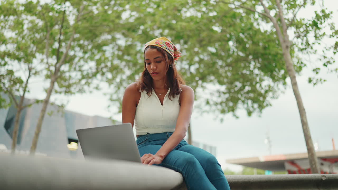 Woman working on laptop in park