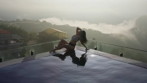 mujer asiática delgada y sexy posando y relajándose en la piscina infinita del hotel indigo alishan en taiwán