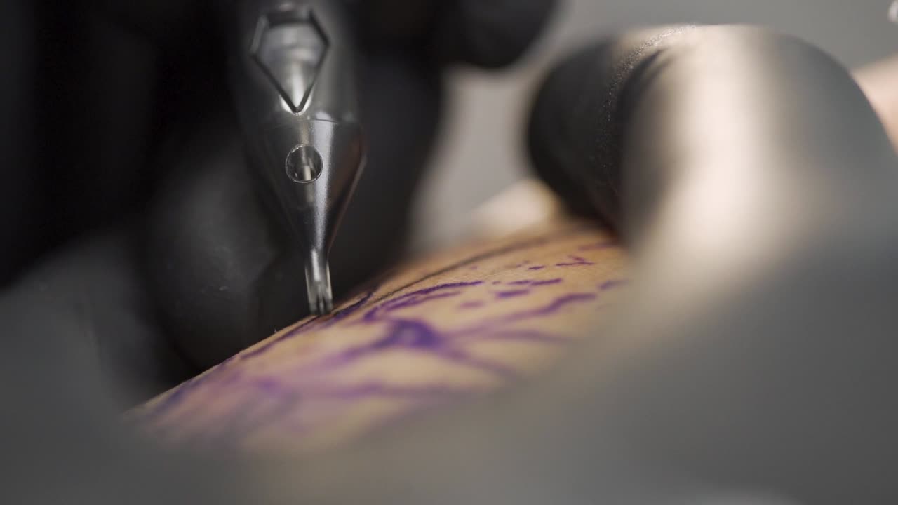 Macro shot of tattooing process in a professional tattoo studio. Shot in slow motion 120fps