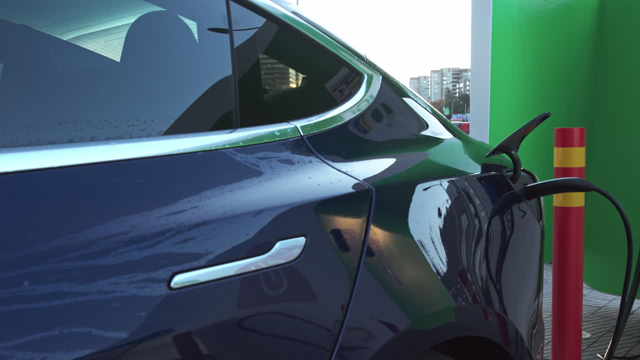 Elektrikli araç şarj portu, EV modern araca takılıyor, ekoloji alternatif enerji sürdürülebilirliği korunuyor