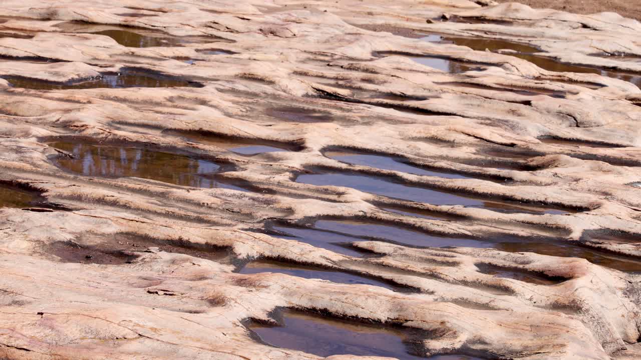 침식된 모래암 바위 층 위로 흐르는 물