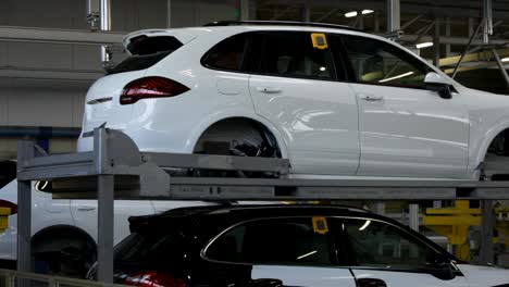 white cars on an assembly line in a factory, daytime, industrial setting