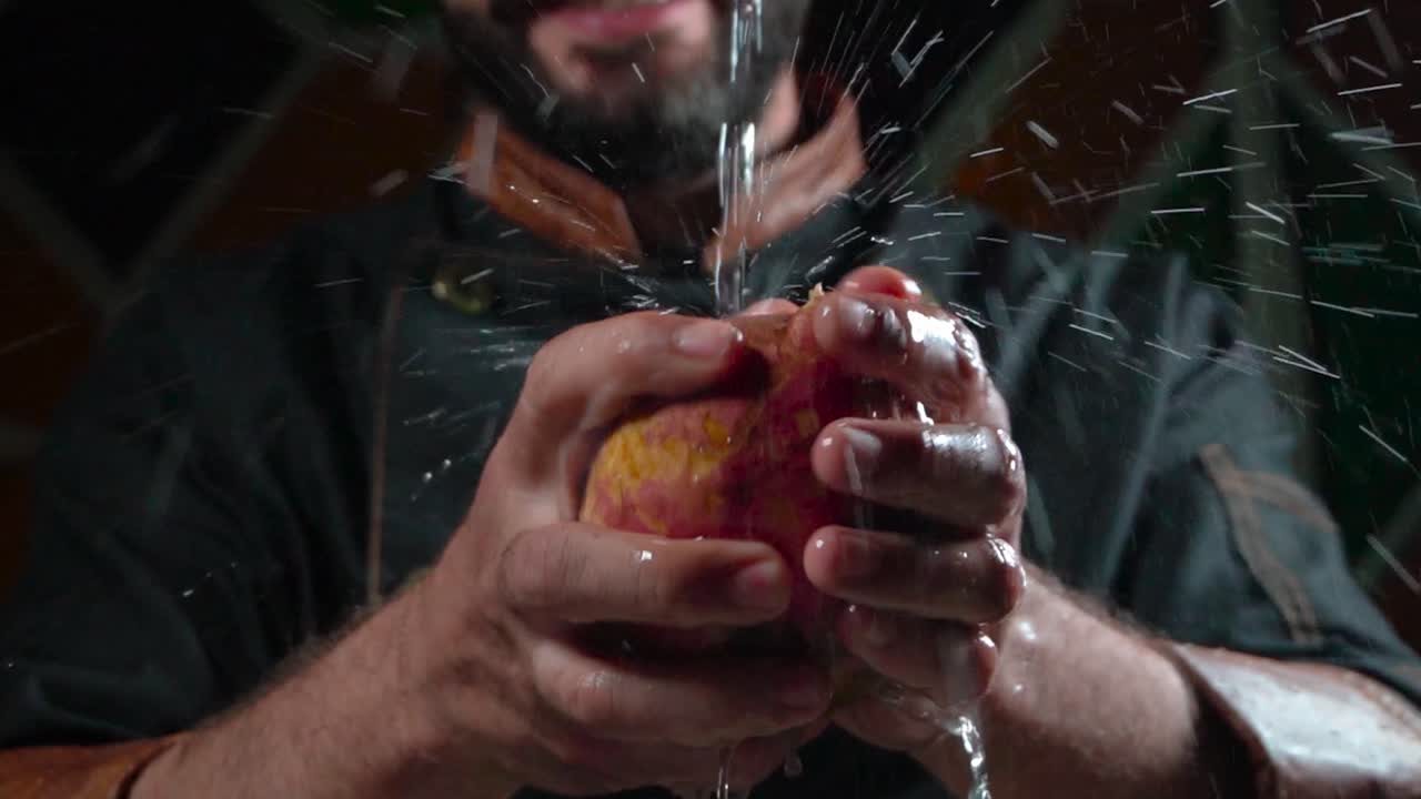 primo piano delle mani di un cuoco che lava una patata sotto l'acqua corrente al rallentatore