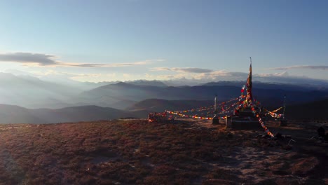 tibet mongolian sacred temple strewn with prayer flags overlook sunrays on valley, xingduqiao yuzixi yala gongga aerial orbit