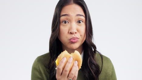 Young-woman,-eating-burger-and-studio-with-face