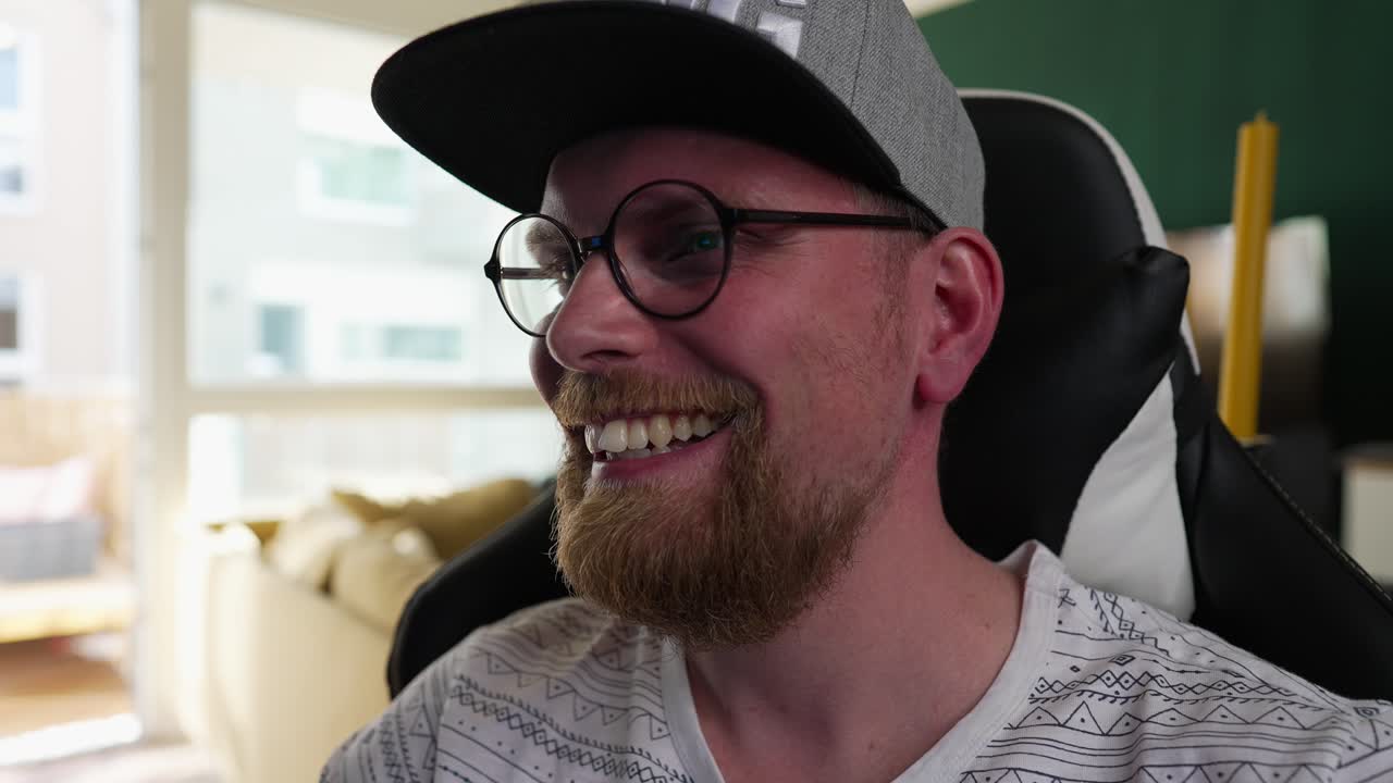 computadoras: el hombre sonríe mirando el contenido de transmisión en pc, zoom en cámara lenta