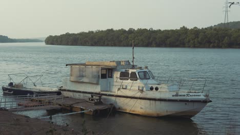 Verlassenes-Boot-Treibt-Verlassen-Am-Hafen-Mit-Blick-Auf-Die-Wunderschönen-Und-Großen-Berge-Dahinter