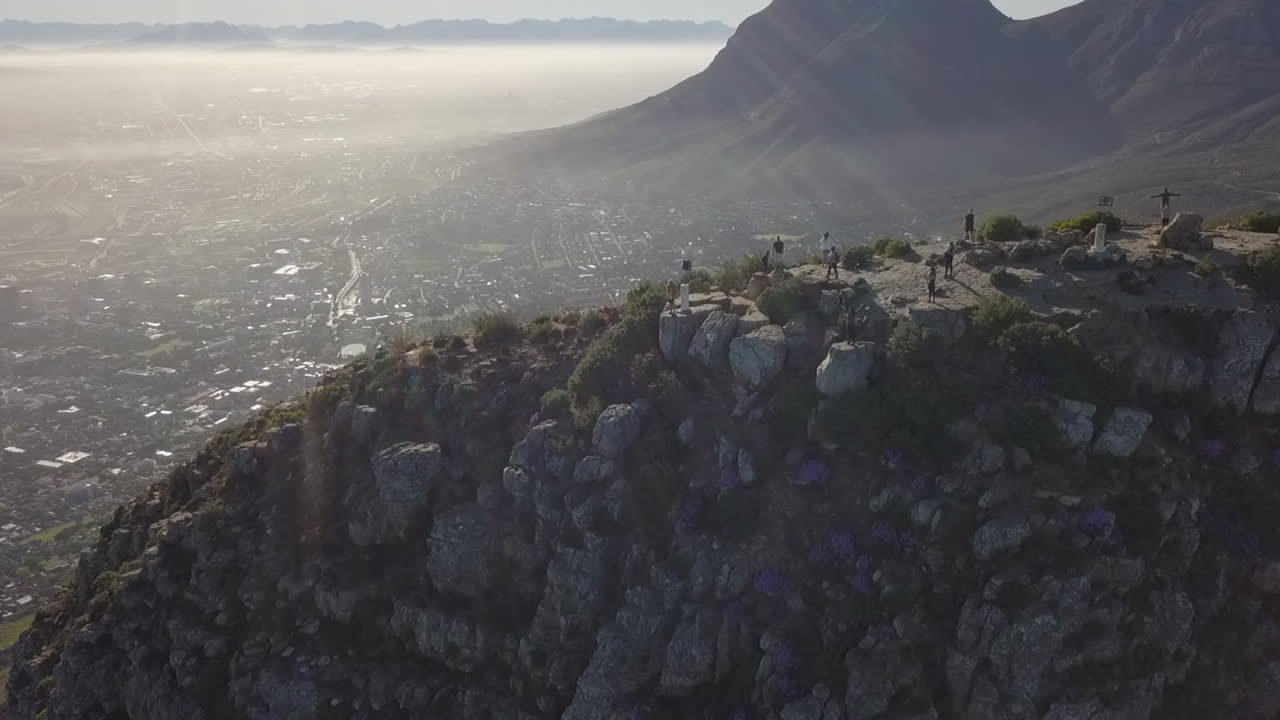 Bagliore delle lenti dei raggi solari mentre un drone vola sopra la cima Lion's Head a Città del Capo.