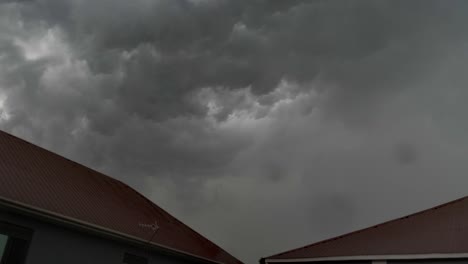 Un-Lapso-De-Tiempo-De-Nubes-De-Tormenta-Rodando-En-El-Cielo-Sobre-Dos-Edificios