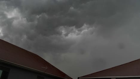 un lapso de tiempo de nubes de tormenta rodando en el cielo sobre dos edificios