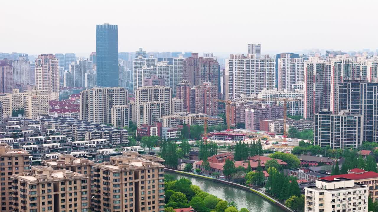 Aerial: Skyscraper buildings, river, and cityscape during a hazy day in Shanghai, China, pan drone shot