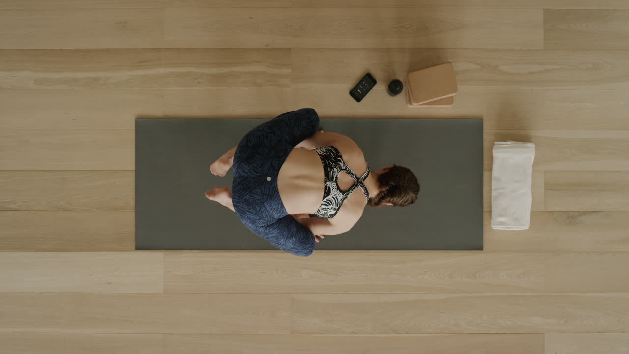 vista superior de la mujer de yoga practicando la pose del cuervo en el estudio de ejercicios disfrutando de un estilo de vida saludable practicando la meditación entrenando en una colchoneta de ejercicios