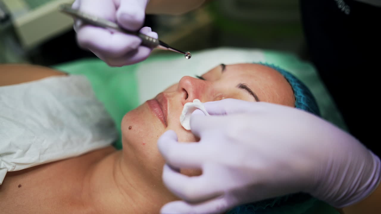 Beautician cleaning pores with the help of special tool. Beauty procedures and skincare at salon. Close up.