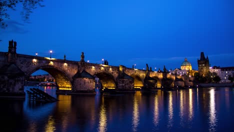 Timelapse-De-La-Puesta-Del-Sol-De-Día-A-Noche-Mientras-El-Puente-De-Carlos-En-Praga,-República-Checa,-Se-Ilumina-Durante-La-Noche-Con-Una-Vista-De-La-Torre-Del-Puente-De-La-Ciudad-Vieja