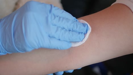 close-up sterilizing a patient's arm before drawing a blood sample