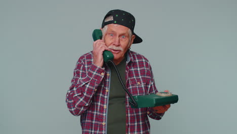 cheerful tourist man secretary talking on wired vintage telephone of 80s, says hey you call me back