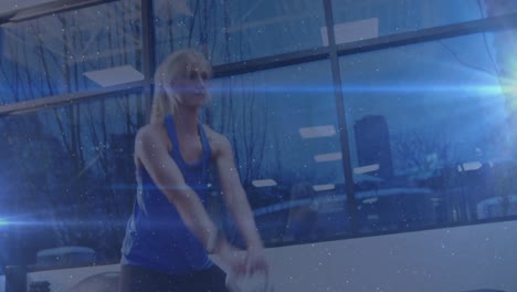 Animation-of-Caucasian-woman-exercising-with-glowing-blue-light-moving-in-the-foreground