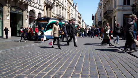 busy city street with pedestrians and tram